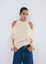 Jersey de punto color crudo, de diseño fluido con cuello redondo, hombros descubiertos y mangas abullonadas.
