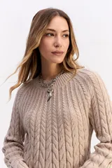 Buzo de punto negro con diseño de trenzas en relieve, cuello redondo y mangas largas.