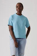 Remera celeste de manga corta, con cuello redondo y diseño holgado con aberturas laterales en el dobladillo.
