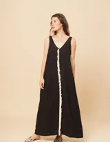 Vestido largo blanco de lino con escote en V y flecos de algodón en los bordes.