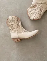 Bota corta estilo western de cuero color marrón, con taco cuadrado de 5 cm y diseño clásico. Presenta un acabado desgastado en la puntera y el talón.