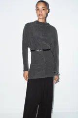 Vestido corto de tejido suave color gris oscuro, con cuello redondo y manga larga. Incluye un cinturón fino de efecto piel con hebilla metálica dorada.