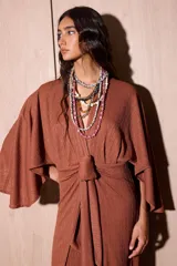 Vestido largo marrón tipo kimono en crepé texturado, con mangas amplias abiertas y tiras ajustables para atar en la cintura.