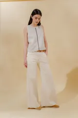 Pantalón de jean color crudo, de tiro medio y pierna ancha, con cinco bolsillos y pespuntes a contratono.