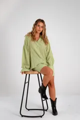Conjunto de dos piezas color negro compuesto por una camisa de manga larga con botones frontales y un short de tiro alto con cintura elástica.