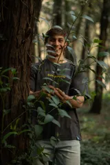 Remera gris oscuro de manga corta raglán, confeccionada en algodón. Presenta costuras a la vista en color amarillo.