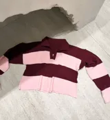 Sweater de punto a rayas horizontales en color bordó y rosado, con cuello polo y diseño corto.