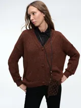 Cardigan de punto color marrón con destellos brillantes, escote en V y cierre frontal de botones. Presenta mangas largas con puños acanalados y un corte holgado.