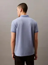 Chomba azul de poliéster con monograma de Calvin Klein, corte regular, mangas cortas y cuello polo con cartera de dos botones ocultos.