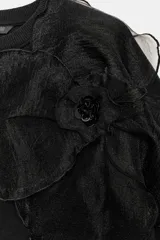 Sudadera de algodón con cuello redondo y manga larga, caracterizada por un detalle de flor con volumen confeccionada en organza sobre el hombro. Presenta terminaciones en rib en puños y ruedo.