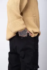 Pantalón cargo negro con múltiples bolsillos laterales y ajuste en los tobillos.