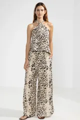 Pantalón de lino italiano con estampado animal print tipo leopardo y cebra, de corte recto y talle medio, con cintura elástica en la parte posterior y aberturas laterales en el bajo.