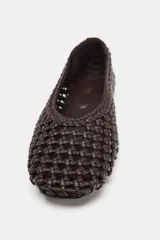 Zapato tipo bailarina color marrón oscuro con cuerpo trenzado y acabado en punta redonda, con suela plana.