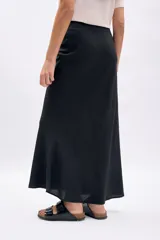 Pollera larga de corte evasé en color negro, confeccionada en tela liviana con caída fluida.