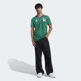Camiseta de fútbol Adidas de la selección de México, primera equipación 2026. Diseño en color verde con estampado gráfico inspirado en la cultura azteca, detalles en blanco y rojo en el cuello y las mangas, logo de la marca y escudo de la selección en el pecho.