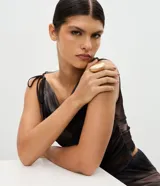 Maxi anillo femenino de metal con acabado en baño de oro batido y diseño ovalado.