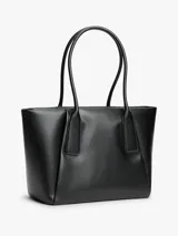 Cartera tote negra Tommy Hilfiger de acabado liso, con dos asas superiores y cierre de cremallera. Incluye un compartimento principal, un bolsillo interior con cremallera y logo metálico en relieve en la parte delantera.