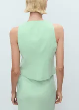 Chaleco verde menta sin mangas, con cuello redondo y cierre frontal con nudos y presillas de tela.