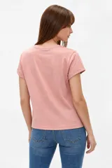 Remera de algodón blanca de manga corta y cuello redondo, con estampa frontal que combina franjas verticales verdes y un diseño ovalado con fresas rojas.