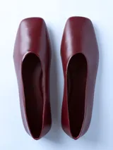 Zapato tipo ballerina de cuero color bordó, con punta cuadrada y suela plana.