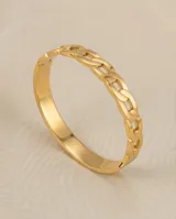 Esclava de acero con baño de oro, con diseño de eslabones tipo cadena en la parte superior y una cadena fina adicional integrada.