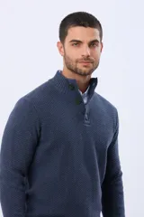 Buzo tejido texturado color verde oscuro, con cuello alto y cierre parcial de tres botones. Tiene mangas largas y un pequeño detalle de etiqueta marrón en el dobladillo inferior.