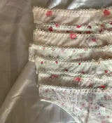 Bombacha colaless confeccionada en microtul translúcido con estampados variados, terminaciones con borde picot y un pequeño moño decorativo en la cintura.