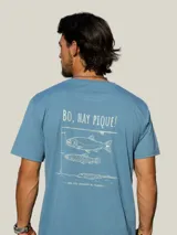 Remera de algodón color azul con estampa gráfica en la espalda que incluye la frase 'Bo, hay pique!' y dibujos de peces con una caña de pescar.