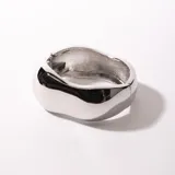 Brazalete rígido plateado con forma irregular.
