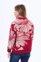 Buzo tejido de punto con diseño floral estampado en contraste, cuello redondo y terminaciones en rib. Presenta un calce holgado y mangas largas.