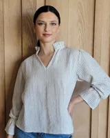 Blusa de algodón con cuello mao y volados, mangas largas con puños elásticos y corte holgado.