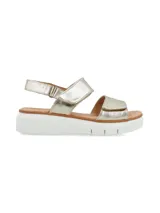Sandalia de cuero metalizado color dorado con dos tiras de ajuste con velcro y plataforma baja de poliuretano blanco.