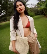 Blazer femenino color beige, de corte holgado, con cuello inglés, solapas y cierre frontal con un botón. Confeccionado en viscolino (viscosa y lino).