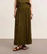 Pollera evasê midi color verde militar, confeccionada en crepé con cintura ancha con trabillas en los laterales y elástico detrás de la cintura. Incluye cinturón de cuerda para lazo con abalorios de puntas.