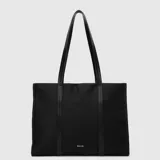 Bolso tote de diseño urbano color negro, con doble asa de hombro y cierre superior. Presenta detalles de tiras verticales sobre el cuerpo y logo minimalista estampado en la parte inferior.