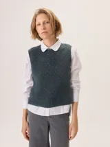 Chaleco de punto con textura jaspeada, cuello redondo y corte recto, ideal para superponer sobre camisas.