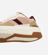 Championes urbanos de diseño moderno con recortes en tonos tierra y detalles en color bordó. Presentan suela tipo caja, cordones frontales, lengüeta acolchada y talón estructurado con acabado aterciopelado.