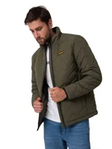 Chaqueta acolchada de color verde oliva, con cierre frontal de cremallera, cuello alto y parche con el logo de la marca en el pecho. Presenta un diseño de costuras en zigzag y es resistente al agua y al viento.