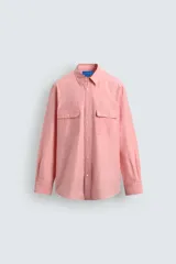 Camisa de corte relajado confeccionada en mezcla de algodón y seda, color rosado. Presenta cuello solapa, cierre frontal de botones, mangas largas con puños abotonados y dos bolsillos de plastrón con solapa en el pecho.