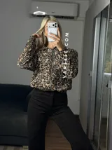 Campera bomber de gamuza con textura de corderoy, con estampado animal print de leopardo, cuello camisero, cierre frontal completo y bolsillos delanteros.