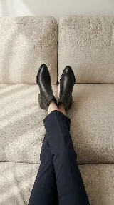 Bota corta tipo chelsea de cuero negro, con panel lateral texturizado y taco cuadrado bajo.