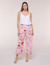 Pantalón crop de lino y rayón, con diseño wide leg de corte holgado, estampado tropical de hojas en tonos verde, azul y marrón sobre fondo blanco. Cuenta con pretina trasera elastizada y bolsillos delanteros.