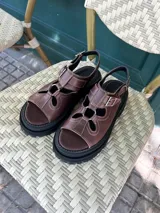 Sandalias de cuero color chocolate con plataforma track y aberturas decorativas.