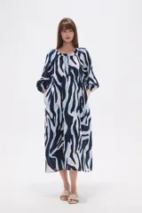 Vestido midi holgado con estampado de hojas en tonos verde y beige, cuello redondo con abertura en V y botones, y mangas 3/4 abullonadas.