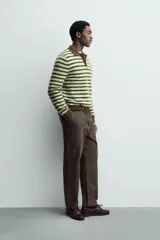 Polo de punto de manga larga con diseño de rayas horizontales en tonos verde y marrón. Presenta cuello solapa, cierre frontal con botonadura y acabados en rib en puños y ruedo.