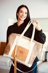 Bolso shopper grande de cuero, modelo Iris de Lorena Caprile, en combinación de tonos beige, marrón claro y textura símil cocodrilo. Cuenta con asas largas de hombro, bolsillo frontal con aplique de gamuza y detalle de flecos colgantes.