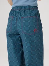 Pantalón de pierna recta de tiro alto con estampa geométrica y cintura elastizada. Presenta detalles y vivos en rojo en la cintura y costuras laterales.
