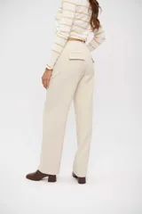 Pantalón de vestir color beige claro, tiro alto, de corte ancho y pierna recta.