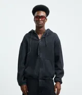 Campera bomber de jean en color azul medio, con cierre frontal de cremallera, capucha ajustable con cordones, bolsillos frontales y terminaciones elásticas en puños y cintura.