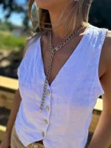 Collar plateado tipo corbatín, con cadena de eslabones gruesos y cierre de mosquetón.